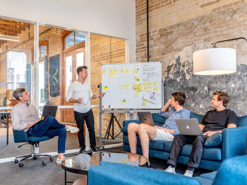 Group of people meeting around a whiteboard